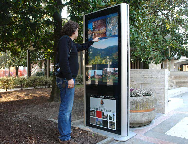A man touches an interactive map kiosk